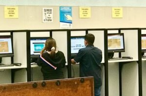 Applicants taking their driver license knowledge test on computer terminals inside a local DMV office